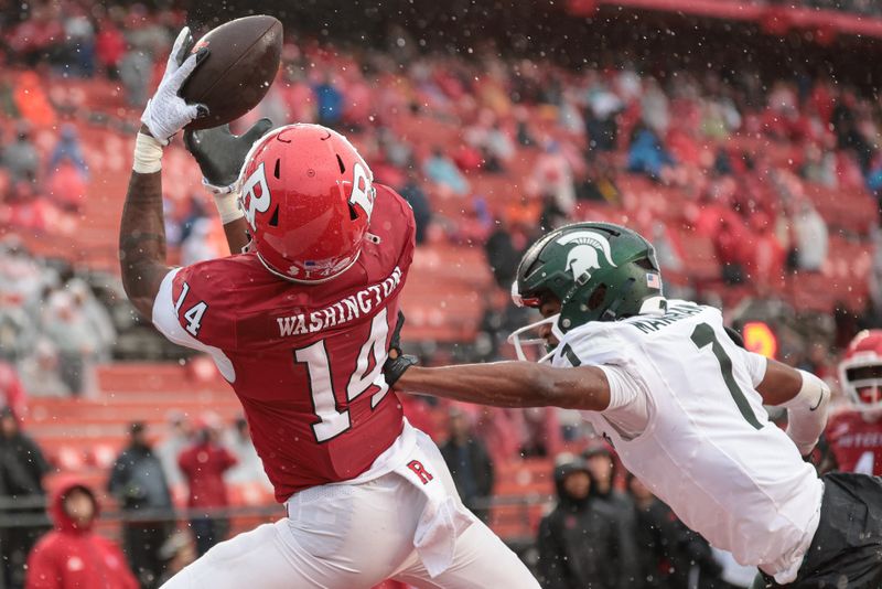 Oct 14, 2023; Piscataway, New Jersey, USA; Rutgers Scarlet Knights wide receiver Isaiah Washington (14) catches a touchdown pass as Michigan State Spartans defensive back Jaden Mangham (1) defends during the second half at SHI Stadium. Mandatory Credit: Vincent Carchietta-USA TODAY Sports