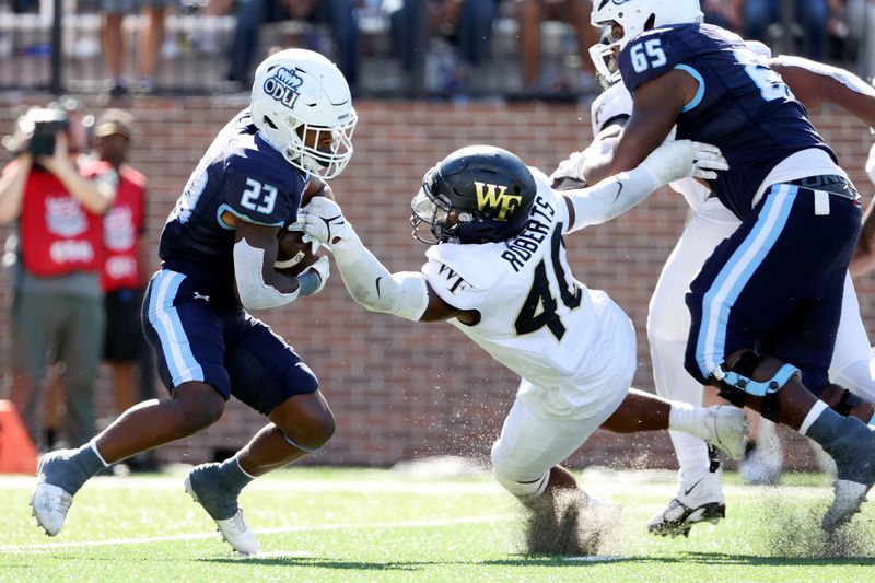 Sep 16, 2023; Norfolk, Virginia, USA; Old Dominion Monarchs running back Devin Roche (23) runs the ball against Wake Forest Demon Deacons linebacker Jacob Roberts (40) during the fourth quarter at Kornblau Field at S.B. Ballard Stadium. Mandatory Credit: Peter Casey-USA TODAY Sports