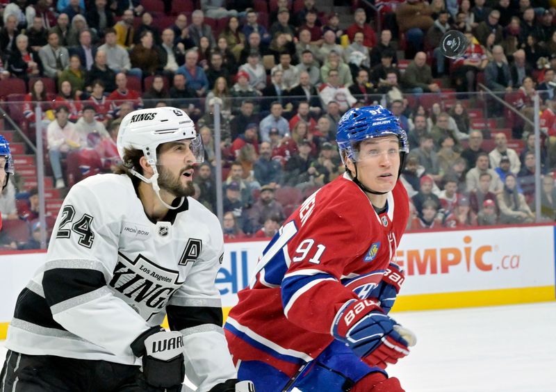 Oct 17, 2024; Montreal, Quebec, CAN; Los Angeles Kings forward Philllip Danault (24) and Montreal Canadiens forward Oliver Kapanen (91) track the puck during the first period at the Bell Centre. Mandatory Credit: Eric Bolte-Imagn Images