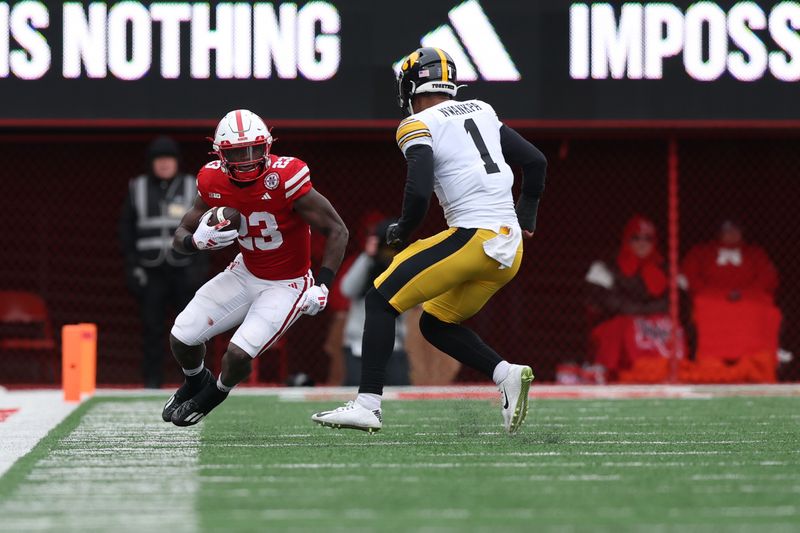 Nov 24, 2023; Lincoln, Nebraska, USA; Iowa Hawkeyes defensive back Xavier Nwankpa (1) looks to tackle Nebraska Cornhuskers running back Anthony Grant (23) at Memorial Stadium. Mandatory Credit: Reese Strickland-USA TODAY Sports