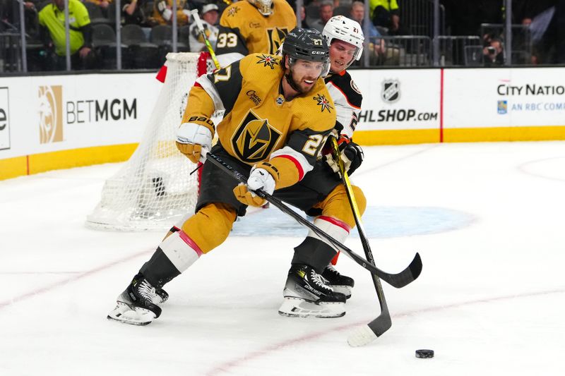 Apr 18, 2024; Las Vegas, Nevada, USA; Vegas Golden Knights defenseman Shea Theodore (27) protects the puck from Anaheim Ducks center Isac Lundestrom (21) during the first period at T-Mobile Arena. Mandatory Credit: Stephen R. Sylvanie-USA TODAY Sports