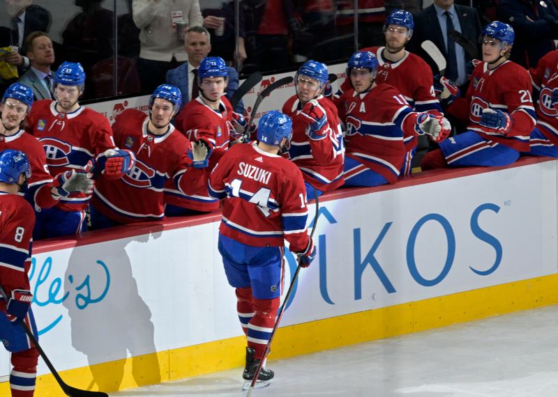 Jan 25, 2024; Montreal, Quebec, CAN; Montreal Canadiens forward Nick Suzuki (14) celebrates with teammates after scoring a goal against the New York Islanders during the first period at the Bell Centre. Mandatory Credit: Eric Bolte-USA TODAY Sports