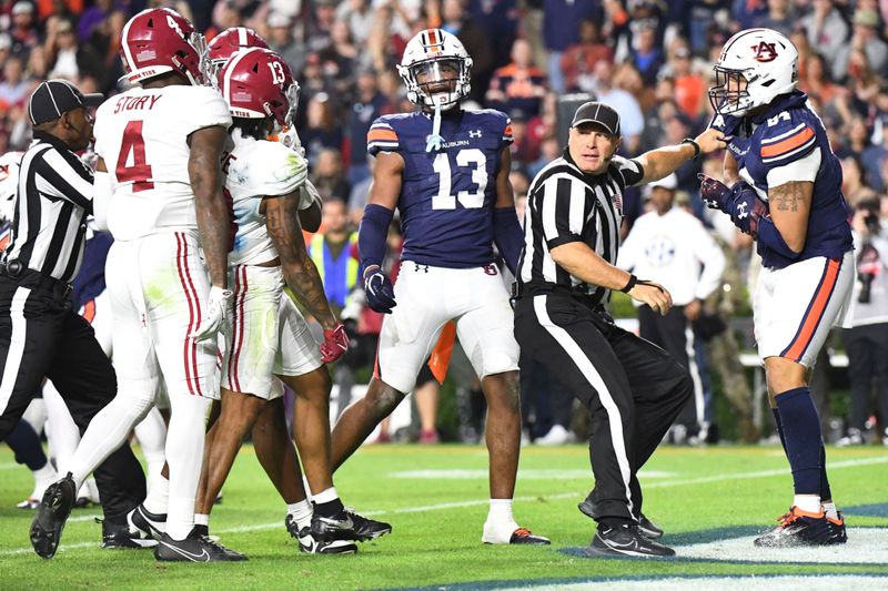 Nov 25, 2023; Auburn, Alabama, USA; Officials break up a shoving match between players from the Alabama Crimson Tide and Auburn Tigers in the fourth quarter at Jordan-Hare Stadium. Alabama won 27-24. Mandatory Credit: Gary Cosby Jr.-USA TODAY Sports