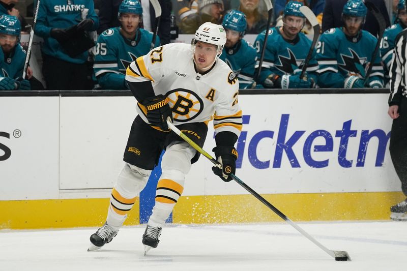 Nov 23, 2025; San Jose, California, USA;  Boston Bruins defenseman Hampus Lindholm (27) looks to pass against the San Jose Sharks in the first period at SAP Center in San Jose. Mandatory Credit: David Gonzales-Imagn Images