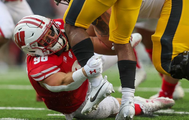 Oct 14, 2023; Madison, Wisconsin, USA; Wisconsin Badgers linebacker C.J. Goetz (98) tackles Iowa Hawkeyes running back Leshon Williams (4) at Camp Randall Stadium. Mandatory Credit: Tork Mason-USA TODAY Sports