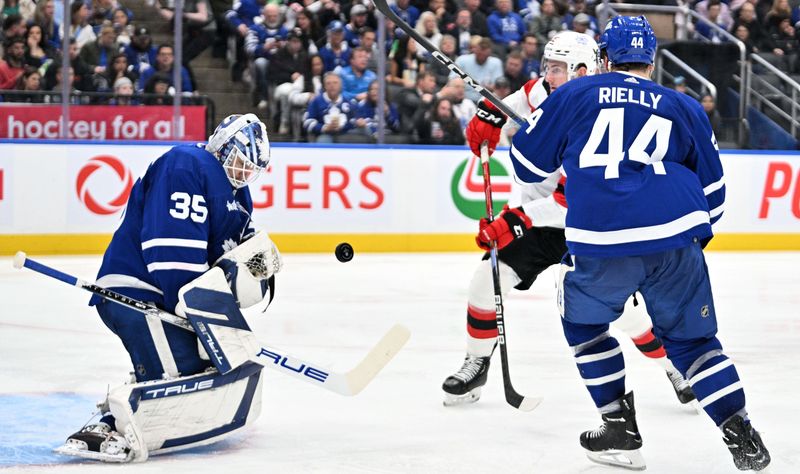 Apr 11, 2024; Toronto, Ontario, CAN; Toronto Maple Leafs goalie Ilya Samsonov (35) makes a save as defenseman Morgan Rielly (44) covers New Jersey Devils forward Nolan Foote (25) in the second period at Scotiabank Arena. Mandatory Credit: Dan Hamilton-USA TODAY Sports