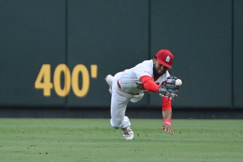 Apr 10, 2024; St. Louis, Missouri, USA;  St. Louis Cardinals center fielder Victor Scott II (11) dives but is unable to catch a line drive hit by Philadelphia Phillies catcher J.T. Realmuto (not pictured) during the seventh inning at Busch Stadium. Mandatory Credit: Jeff Curry-USA TODAY Sports