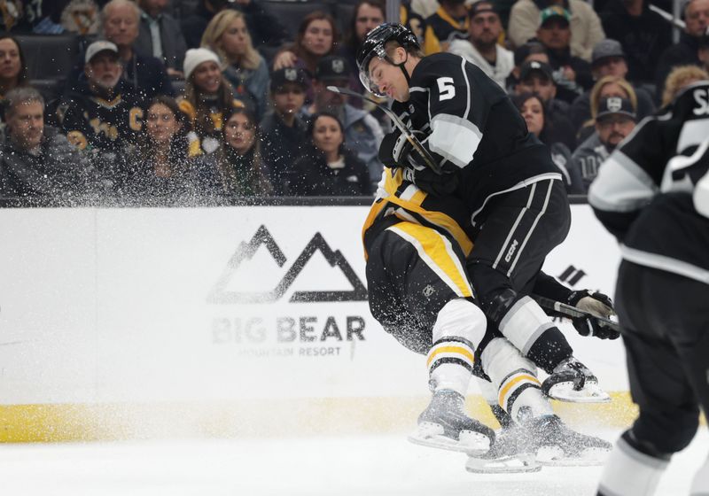 Nov 9, 2023; Los Angeles, California, USA; Los Angeles Kings defensemen Andreas Englund (5) checks Pittsburgh Penguins left wing Radim Zohorna (63) during the first period at Crypto.com Arena. Mandatory Credit: Yannick Peterhans-USA TODAY Sports