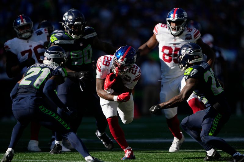 New York Giants running back Tyrone Tracy Jr. (29) runs with the football as Seattle Seahawks cornerbacks Devon Witherspoon (21), left, and Tre Brown (22), right, look to tackle during the second half of an NFL football game, Sunday, Oct. 6, 2024, in Seattle. (AP Photo/Lindsey Wasson)