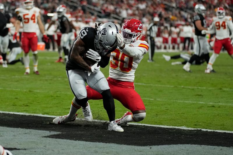 Las Vegas Raiders wide receiver DJ Turner (19) catches a touchdown pass as Kansas City Chiefs cornerback Christian Roland-Wallace (30) defends during the second half of an NFL football game Sunday, Oct. 27, 2024, in Las Vegas. (AP Photo/John Locher)