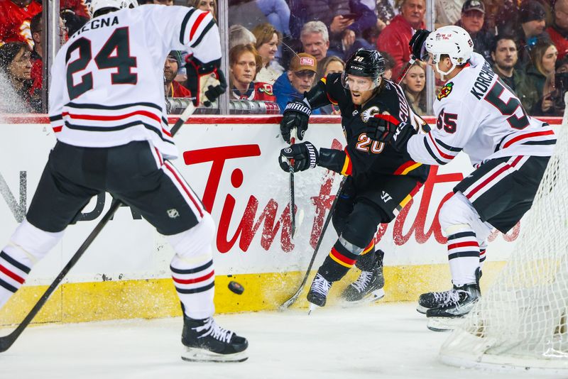 Jan 27, 2024; Calgary, Alberta, CAN; Calgary Flames center Blake Coleman (20) and Chicago Blackhawks defenseman Kevin Korchinski (55) battles for the puck during the second period at Scotiabank Saddledome. Mandatory Credit: Sergei Belski-USA TODAY Sports