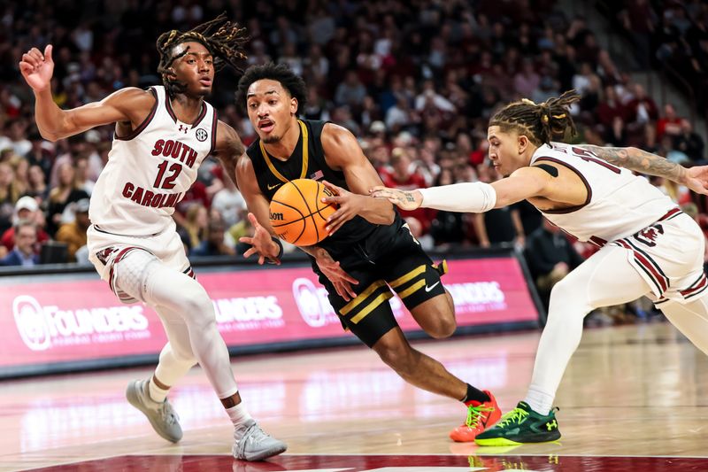 Feb 10, 2024; Columbia, South Carolina, USA; South Carolina Gamecocks guard Ebrima Dibba (0) drives between South Carolina Gamecocks guard Zachary Davis (12) and guard Myles Stute (10) in the second half at Colonial Life Arena. Mandatory Credit: Jeff Blake-USA TODAY Sports