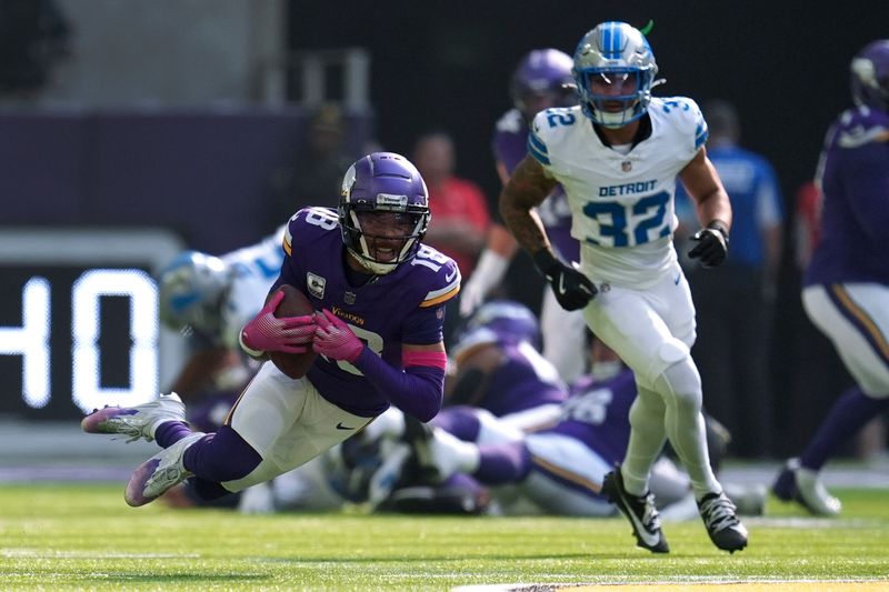 Minnesota Vikings wide receiver Justin Jefferson (18) catches a pass as Detroit Lions safety Brian Branch (32) defends during the first half of an NFL football game Sunday, Oct. 20, 2024, in Minneapolis. (AP Photo/Abbie Parr)