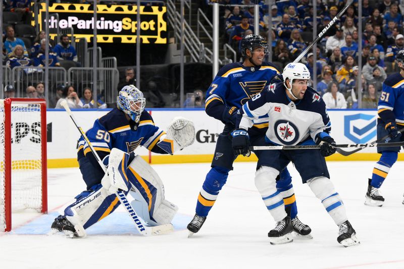 Oct 22, 2024; St. Louis, Missouri, USA; St. Louis Blues goaltender Jordan Binnington (50) and defenseman Pierre-Olivier Joseph (77) defend the net from Winnipeg Jets left wing Alex Iafallo (9) during the third period at Enterprise Center. Mandatory Credit: Jeff Le-Imagn Images 