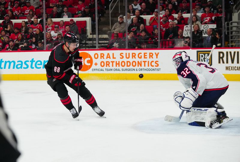 Apr 7, 2024; Raleigh, North Carolina, USA;  Columbus Blue Jackets goalie Malcolm Subban (32) stops the scoring attempt by Carolina Hurricanes center Martin Necas (88) during the third period at PNC Arena. Mandatory Credit: James Guillory-USA TODAY Sports