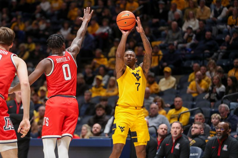 Jan 7, 2025; Morgantown, West Virginia, USA; West Virginia Mountaineers guard Javon Small (7) shoots a three pointer over Arizona Wildcats guard Jaden Bradley (0) during the first half at WVU Coliseum. Mandatory Credit: Ben Queen-Imagn Images