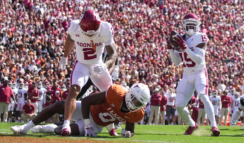 Oct 7, 2023; Dallas, Texas, USA; Oklahoma Sooners defensive back Kendel Dolby (15) pulls down the interception against Texas Longhorns tight end Ja'Tavion Sanders (0) in the first quarter at the Cotton Bowl. This game makes up the 119th rivalry match up. Mandatory Credit: Ricardo B. Brazziell-USA TODAY Sports