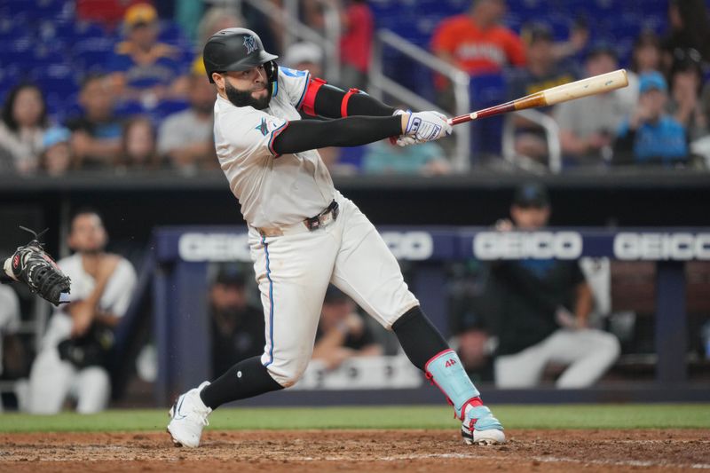 May 21, 2024; Miami, Florida, USA; Miami Marlins third baseman Emmanuel Rivera (15) hits a single that scored a run in the sixth inning against the Milwaukee Brewers at loanDepot Park. Mandatory Credit: Jim Rassol-USA TODAY Sports