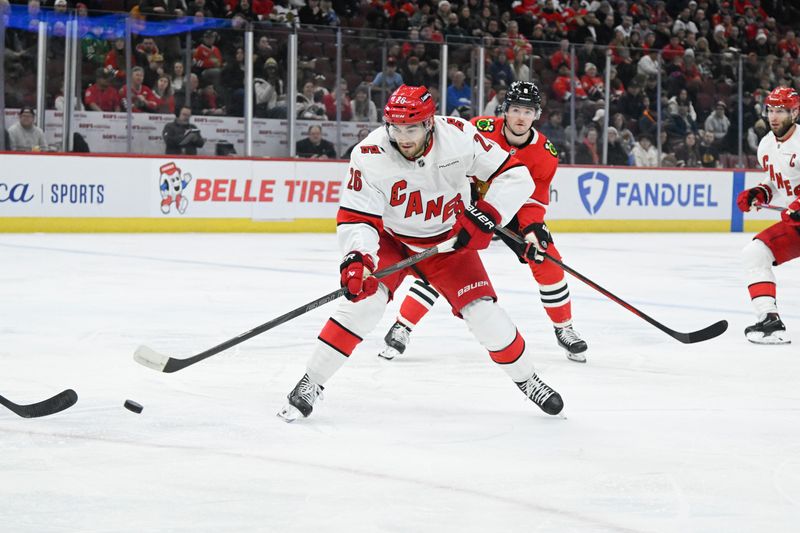 Jan 20, 2025; Chicago, Illinois, USA;  Carolina Hurricanes defenseman Sean Walker (26) moves the puck against the Chicago Blackhawks during the first period at the United Center. Mandatory Credit: Matt Marton-Imagn Images


