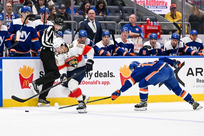 Jan 27, 2024; Elmont, New York, USA; Florida Panthers defenseman Brandon Montour (62) skates a across the blue line defended by New York Islanders center Mathew Barzal (13) during the first period at UBS Arena. Mandatory Credit: Dennis Schneidler-USA TODAY Sports