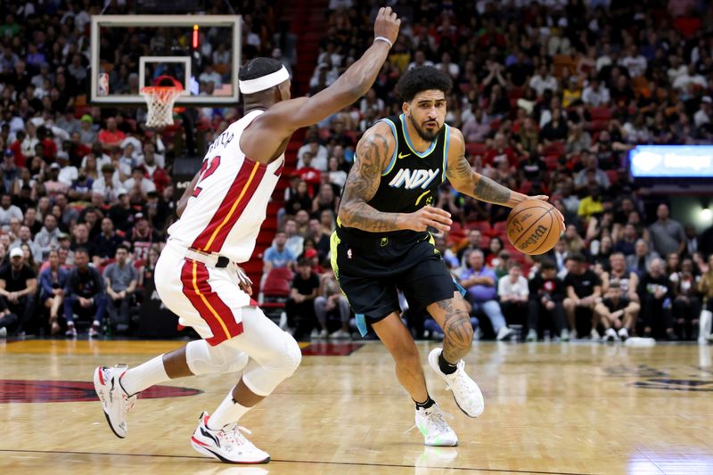 MIAMI, FLORIDA - DECEMBER 02: Obi Toppin #1 of the Indiana Pacers drives against Jimmy Butler #22 of the Miami Heat during the fourth quarter of the game at Kaseya Center on December 02, 2023 in Miami, Florida. NOTE TO USER: User expressly acknowledges and agrees that, by downloading and or using this photograph, User is consenting to the terms and conditions of the Getty Images License Agreement. (Photo by Megan Briggs/Getty Images)