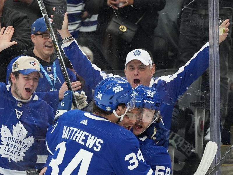 Mar 26, 2024; Toronto, Ontario, CAN; Toronto Maple Leafs left wing Tyler Bertuzzi (59) scores a goal and celebrates with Toronto Maple Leafs center Max Domi (11) and center Auston Matthews (34) against the New Jersey Devils during the first period at Scotiabank Arena. Mandatory Credit: Nick Turchiaro-USA TODAY Sports