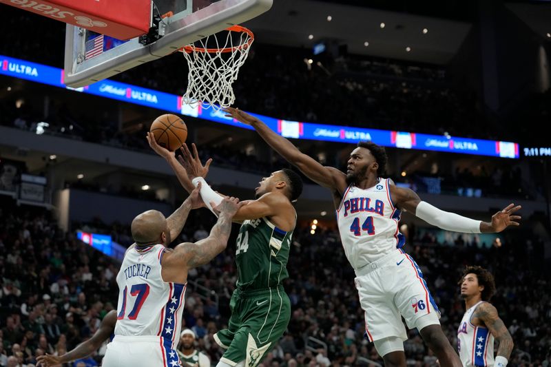 MILWAUKEE, WISCONSIN - OCTOBER 26: Giannis Antetokounmpo #34 of the Milwaukee Bucks shoots the ball against P.J. Tucker #17 and Paul Reed #44 of the Philadelphia 76ers in the first half at Fiserv Forum on October 26, 2023 in Milwaukee, Wisconsin. NOTE TO USER: User expressly acknowledges and agrees that, by downloading and or using this photograph, User is consenting to the terms and conditions of the Getty Images License Agreement. (Photo by Patrick McDermott/Getty Images)