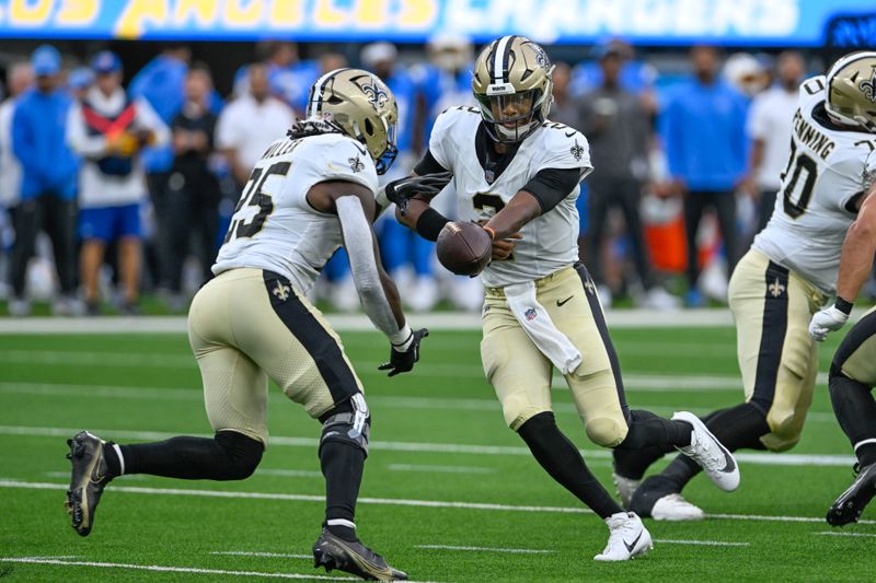 New Orleans Saints quarterback Jameis Winston (2) hands off to running back Kendre Miller (25) in the first half of an NFL football game against the Los Angeles Chargers in Inglewood, Calif., Sunday, Aug. 20, 2023. (AP Photo/Alex Gallardo)