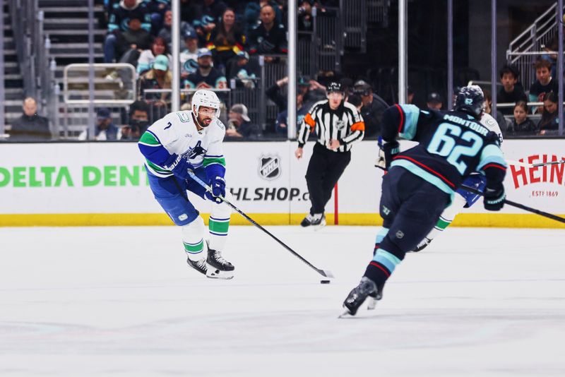 Feb 28, 2026; Seattle, Washington, USA;  Vancouver Canucks defenseman Pierre-Olivier Joseph (7) looks to pass as Seattle Kraken defenseman Brandon Montour (62) defends during the first period at Climate Pledge Arena. Mandatory Credit: Blake Dahlin-Imagn Images