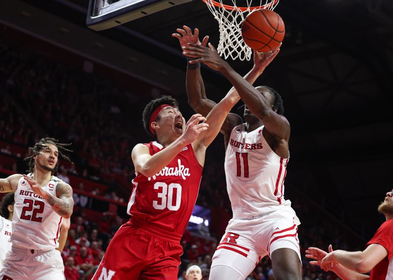 Feb 14, 2023; Piscataway, New Jersey, USA; Nebraska Cornhuskers guard Keisei Tominaga (30) drives to the basket as Rutgers Scarlet Knights center Clifford Omoruyi (11) defends during the first half at Jersey Mike's Arena. Mandatory Credit: Vincent Carchietta-USA TODAY Sports