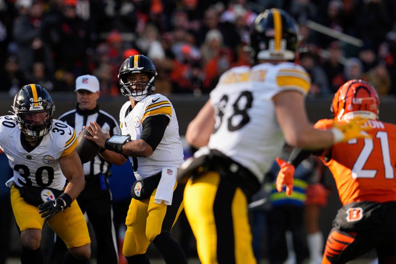 Pittsburgh Steelers quarterback Russell Wilson, third from left, looks for an open receiver during the first half of an NFL football game against the Cincinnati Bengals, Sunday, Dec. 1, 2024, in Cincinnati. (AP Photo/Jeff Dean)