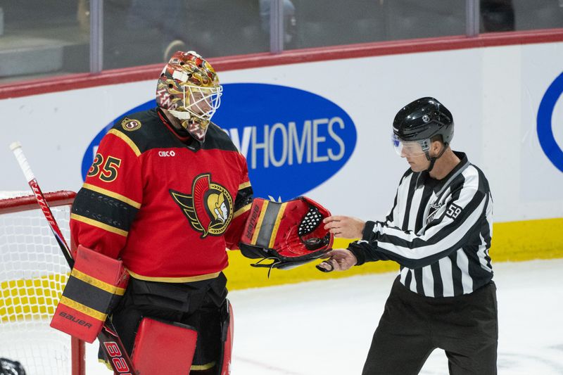 Nov 15, 2025; Ottawa, Ontario, CAN; Linesperson Steve Barton (59) recovers the puck following a save by Ottawa Senators goalie Linus Ullmark (35) in the third period at the Canadian Tire Centre. Mandatory Credit: Marc DesRosiers-IMAGN Images