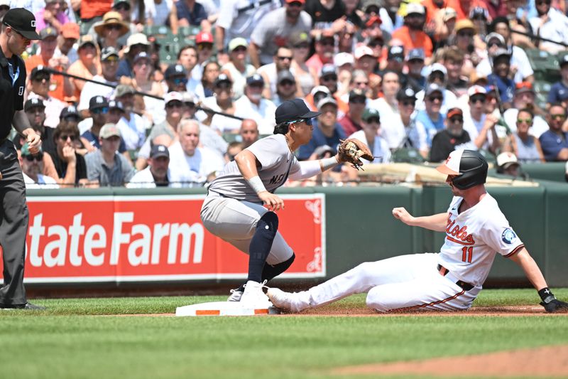 Jul 14, 2024; Baltimore, Maryland, USA;  Baltimore Orioles third base Jordan Westburg (11) is safe at third as New York Yankees third baseman Oswaldo Cabrera (95) fields the ball during the second inning at Oriole Park at Camden Yards. Mandatory Credit: James A. Pittman-USA TODAY Sports