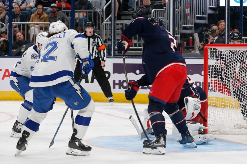 Feb 10, 2024; Columbus, Ohio, USA; Columbus Blue Jackets defenseman Jake Bean (22) clears the rebound of a Elvis Merzlikins (90) save against the Tampa Bay Lightning during the third period at Nationwide Arena. Mandatory Credit: Russell LaBounty-USA TODAY Sports