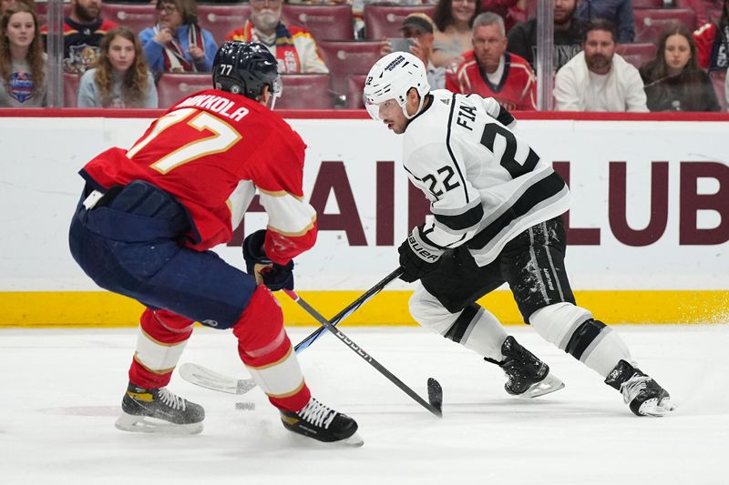 Jan 11, 2024; Sunrise, Florida, USA; Los Angeles Kings left wing Kevin Fiala (22) plays the puck around Florida Panthers defenseman Niko Mikkola (77) during the first period at Amerant Bank Arena. Mandatory Credit: Jasen Vinlove-USA TODAY Sports