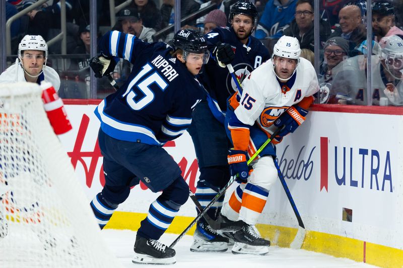 Jan 16, 2024; Winnipeg, Manitoba, CAN; Winnipeg Jets forward Rasmus Kupari (15) battles New York Islanders forward Cal Clutterbuck (15) along the boards during the first period at Canada Life Centre. Mandatory Credit: Terrence Lee-USA TODAY Sports