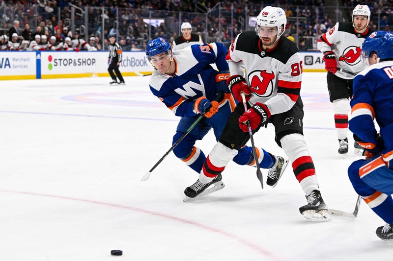 Mar 24, 2024; Elmont, New York, USA;  New York Islanders center Mathew Barzal (13) defends against New Jersey Devils defenseman Kevin Bahl (88) during the first period at UBS Arena. Mandatory Credit: Dennis Schneidler-USA TODAY Sports