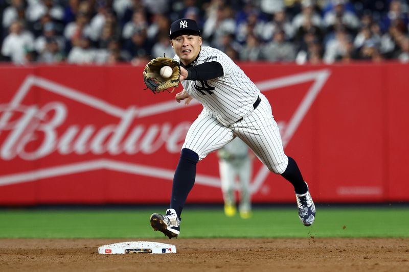 Oct 29, 2024; Bronx, New York, USA; New York Yankees shortstop Anthony Volpe (11) makes a catch to complete a double play against the Los Angeles Dodgers in the second inning during game four of the 2024 MLB World Series at Yankee Stadium. Mandatory Credit: Vincent Carchietta-Imagn Images