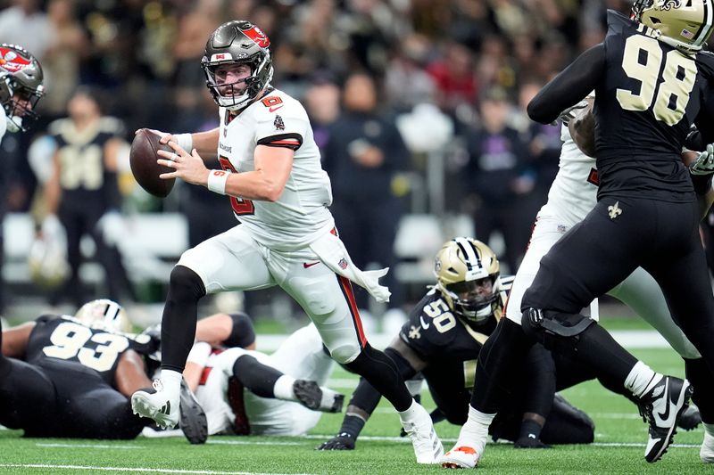 Tampa Bay Buccaneers quarterback Baker Mayfield, middle left, runs against the New Orleans Saints during the first half of an NFL football game in New Orleans, Sunday, Oct. 13, 2024. (AP Photo/Michael Conroy)