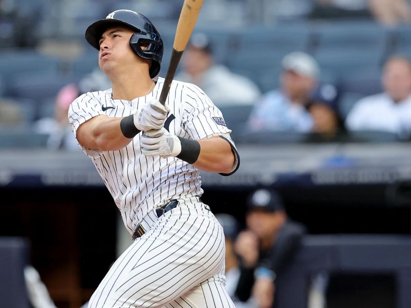 Aug 7, 2024; Bronx, New York, USA; New York Yankees shortstop Anthony Volpe (11) follows through on an RBI double against the Los Angeles Angels during the first inning at Yankee Stadium. Mandatory Credit: Brad Penner-USA TODAY Sports