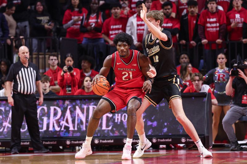 Dec 2, 2025; Piscataway, New Jersey, USA; Rutgers Scarlet Knights center Emmanuel Ogbole (21) is defended by Purdue Boilermakers center Daniel Jacobsen (12) during the first half at Jersey Mike's Arena. Mandatory Credit: Vincent Carchietta-Imagn Images