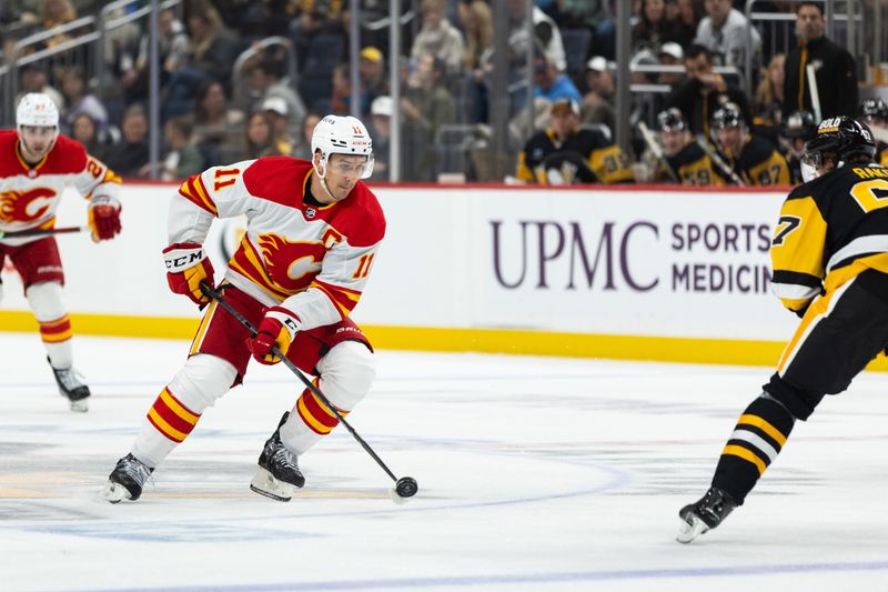 Oct 14, 2023; Pittsburgh, Pennsylvania, USA; Calgary Flames center Mikael Backlund (11) through center ice against the Pittsburgh Penguins during the second period at PPG Paints Arena. Mandatory Credit: Scott Galvin-USA TODAY Sports