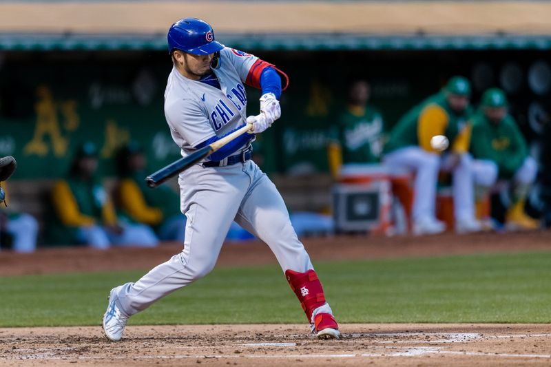 Apr 18, 2023; Oakland, California, USA; Chicago Cubs right fielder Seiya Suzuki (27) hits a single against the Oakland Athletics during the third inning at RingCentral Coliseum. Mandatory Credit: John Hefti-USA TODAY Sports