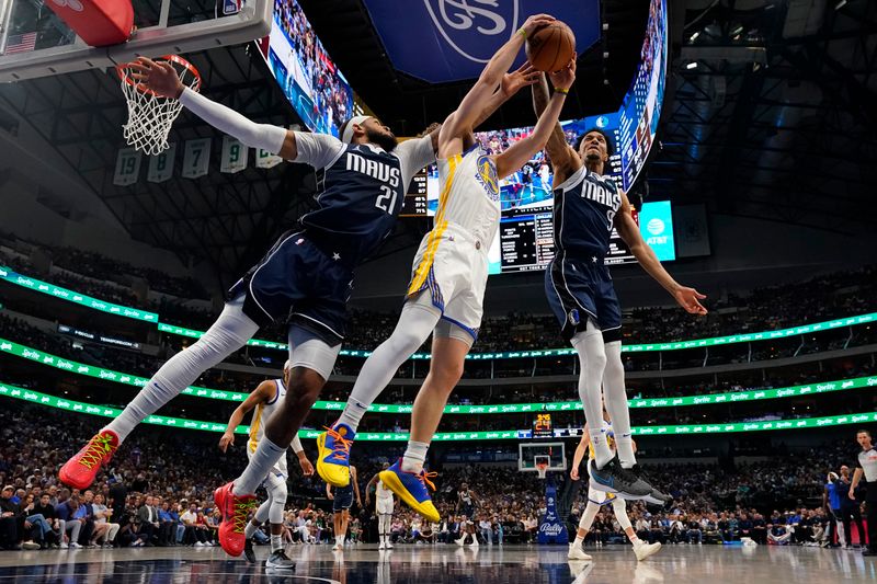 DALLAS, TEXAS - APRIL 05: Daniel Gafford #21 and A.J. Lawson #9 of the Dallas Mavericks compete for a loose ball against Brandin Podziemski #2 of the Golden State Warriors during the first half at American Airlines Center on April 05, 2024 in Dallas, Texas. NOTE TO USER: User expressly acknowledges and agrees that, by downloading and or using this photograph, User is consenting to the terms and conditions of the Getty Images License Agreement. (Photo by Sam Hodde/Getty Images)