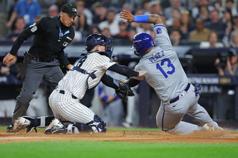 Oct 5, 2024; Bronx, New York, USA; Kansas City Royals catcher Salvador Perez (13) is tagged out by New York Yankees catcher Austin Wells (28) during the second inning during game one of the ALDS for the 2024 MLB Playoffs at Yankee Stadium. Mandatory Credit: Brad Penner-Imagn Images