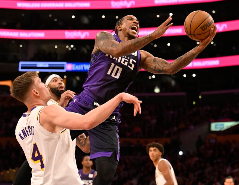 LOS ANGELES, CALIFORNIA - OCTOBER 26: DeMar DeRozan #10 of the Sacramento Kings gets past Anthony Davis #3 and Dalton Knecht #4 of the Los Angeles Lakers in the first half at Crypto.com Arena on October 26, 2024 in Los Angeles, California. NOTE TO USER: User expressly acknowledges and agrees that, by downloading and or using this photograph, User is consenting to the terms and conditions of the Getty Images License Agreement. (Photo by John McCoy/Getty Images)