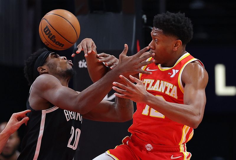 ATLANTA, GEORGIA - DECEMBER 06:  De'Andre Hunter #12 of the Atlanta Hawks battles for the ball against Day'Ron Sharpe #20 of the Brooklyn Nets during the first quarter at State Farm Arena on December 06, 2023 in Atlanta, Georgia.  NOTE TO USER: User expressly acknowledges and agrees that, by downloading and/or using this photograph, user is consenting to the terms and conditions of the Getty Images License Agreement.  (Photo by Kevin C. Cox/Getty Images)