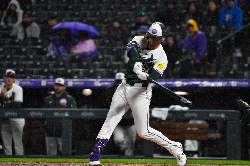 May 11, 2024; Denver, Colorado, USA; Colorado Rockies third base Ryan McMahon (24) singles against the Texas Rangers during the eighth inning at Coors Field. Mandatory Credit: John Leyba-USA TODAY Sports