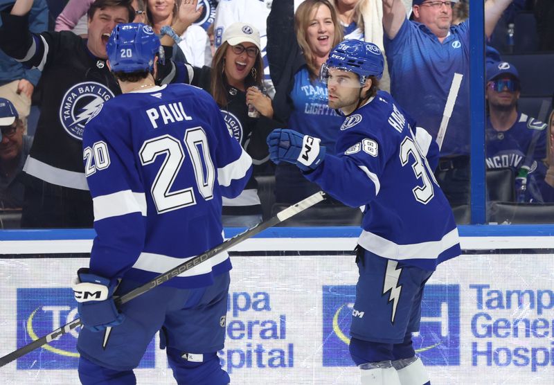 Oct 15, 2024; Tampa, Florida, USA; Tampa Bay Lightning left wing Brandon Hagel (38) is congratulated by left wing Nicholas Paul (20) after he scored against the Vancouver Canucks during the third period at Amalie Arena. Mandatory Credit: Kim Klement Neitzel-Imagn Images