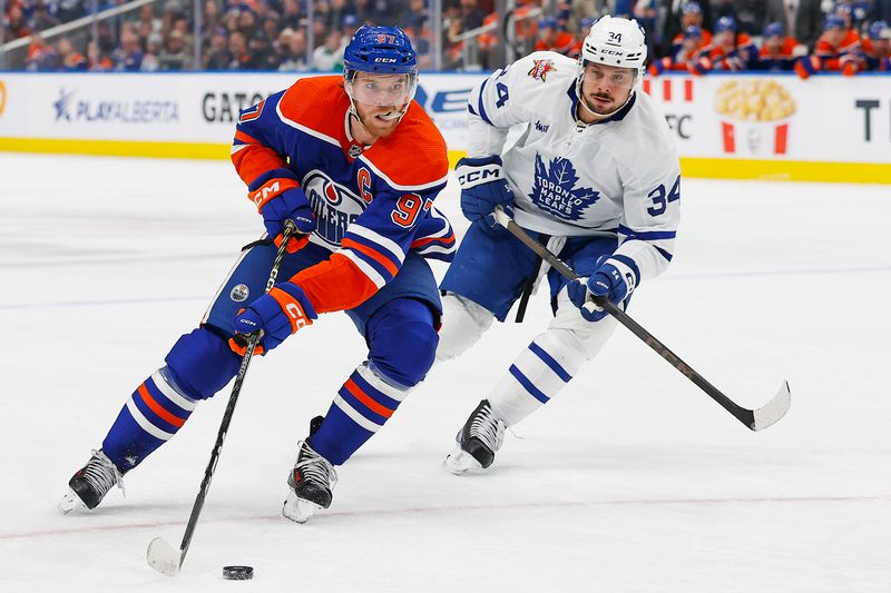 Jan 16, 2024; Edmonton, Alberta, CAN; Edmonton Oilers forward Connor McDavid (97) carries the puck around Toronto Maple Leafs forward Auston Matthews (34) during the first period at Rogers Place. Mandatory Credit: Perry Nelson-USA TODAY Sports